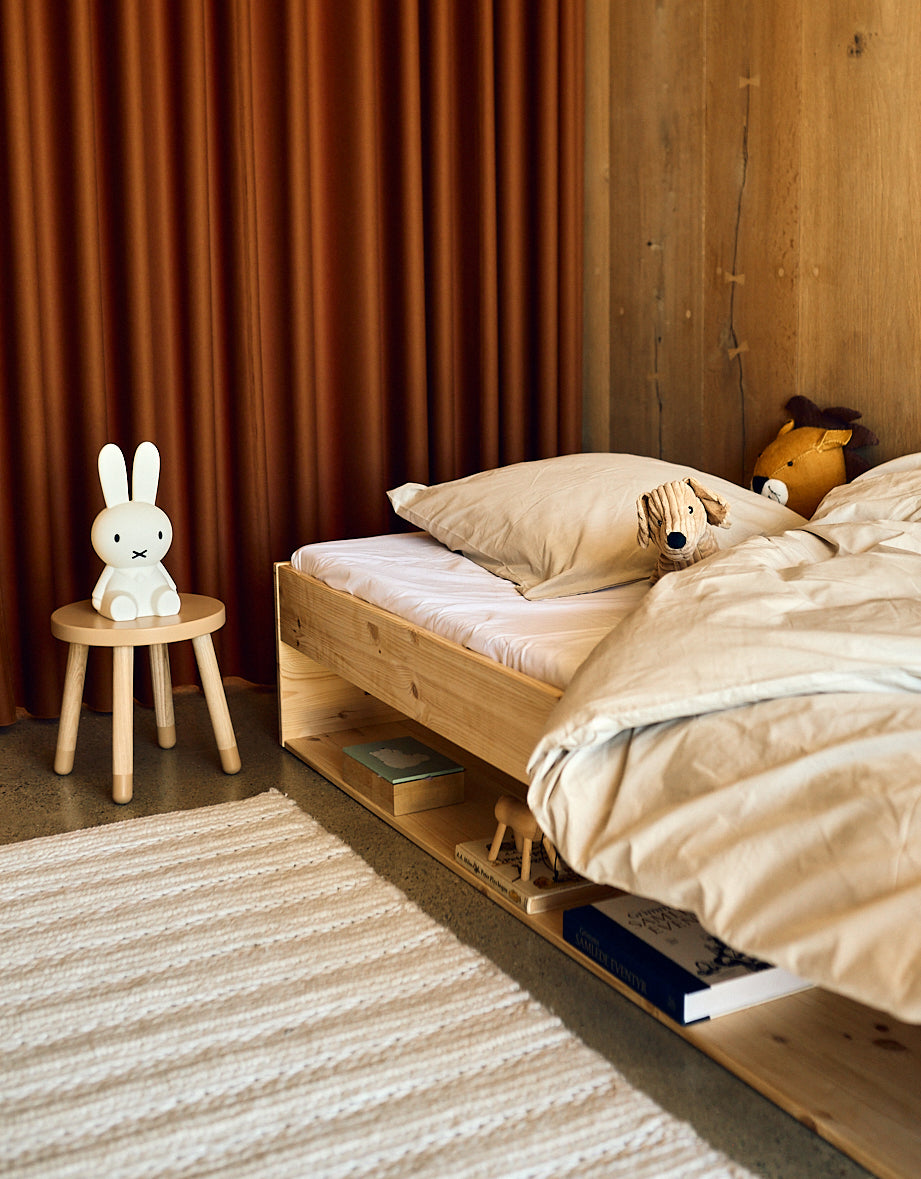FLEXA DOTS Kids Stool in blushing pink, child-safe design, in a children’s room with wooden bed and orange curtain.