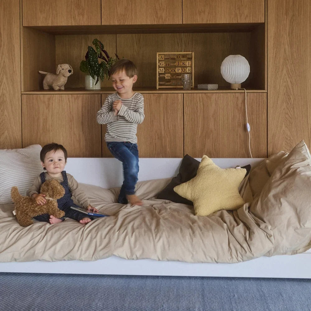 Two children playing on a FLEXA MONTESSORI floor bed